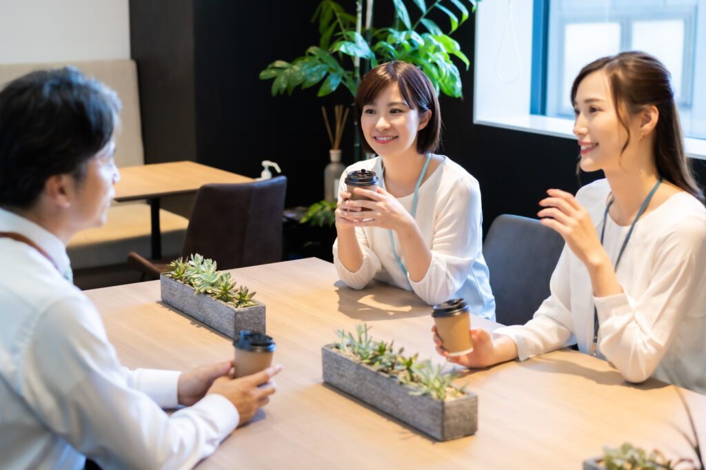 コーヒーを飲みながら談笑してる3人